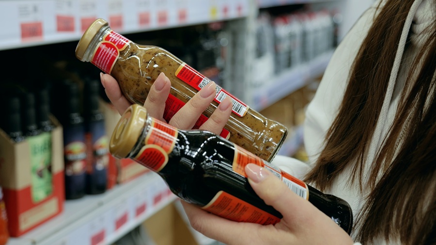 Billede af kvinde, der l&aelig;ser bagsiden p&aring; f&oslash;devarer