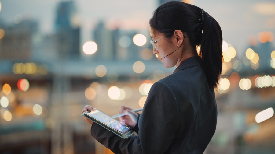 Kvinde, der står med en tablet og arbejder
