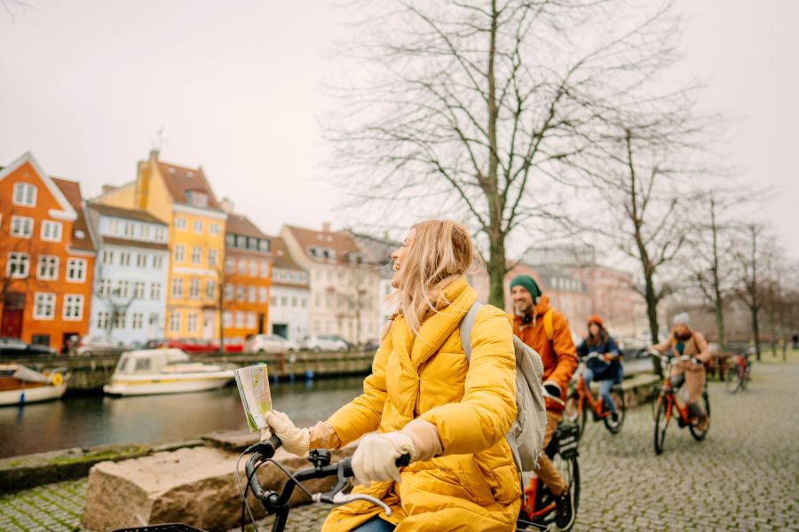 Turister cykler ved Nyhavn i K&oslash;benhavn